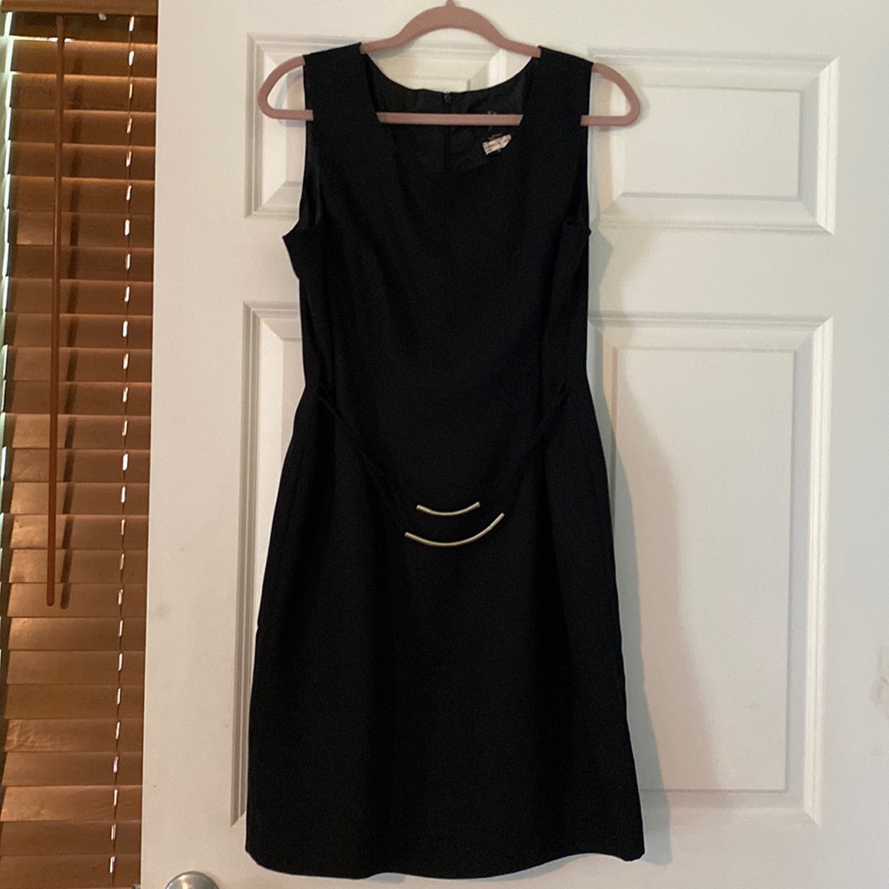 This Dress is your everyday black dress! Size 12, 2 silver accents at waist.